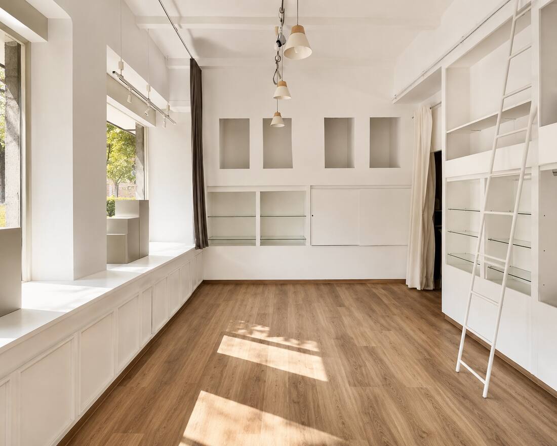 Empty workshop space at Sunday Studios Cologne with display niches and pendant lights